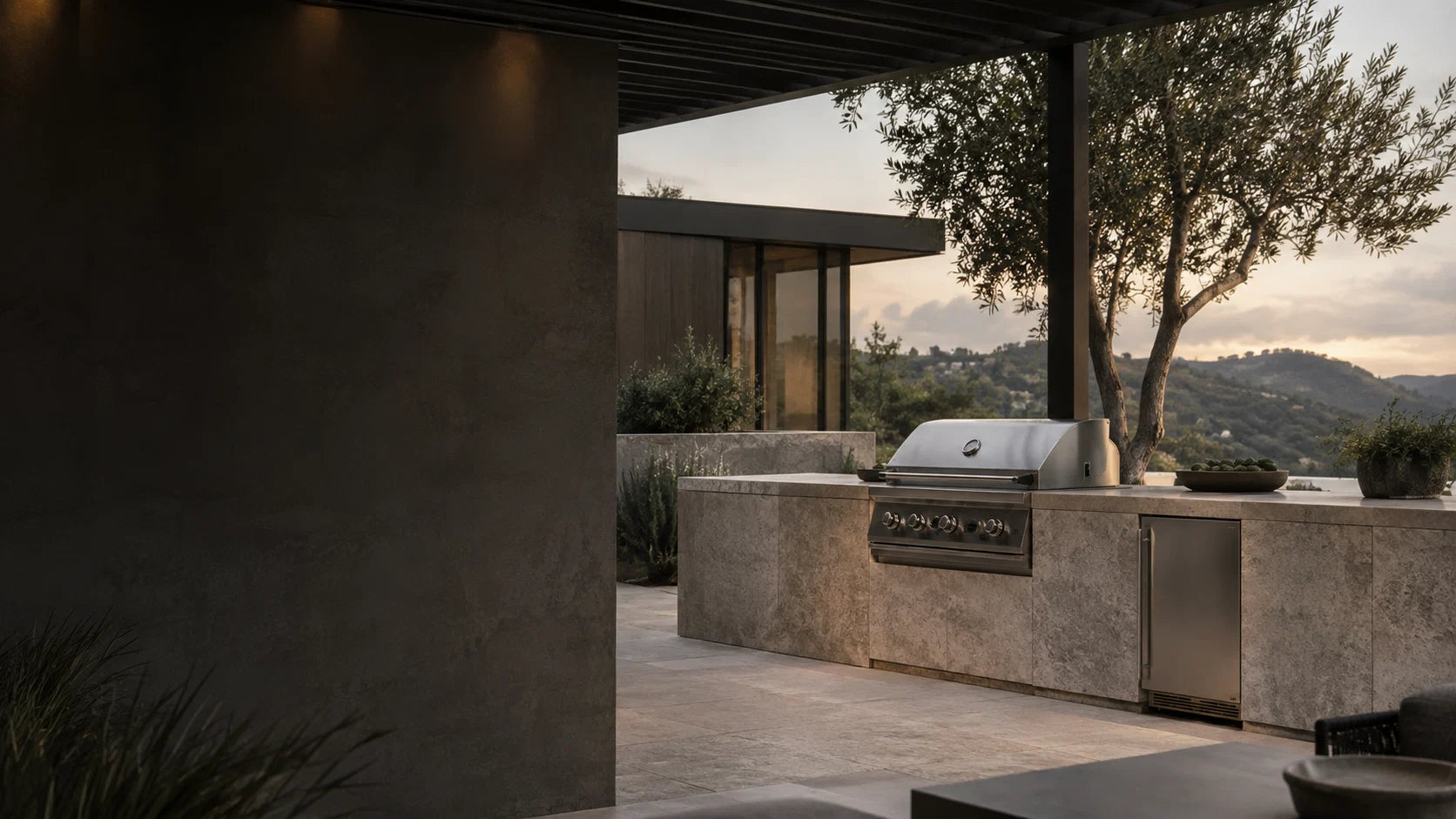 Outdoor kitchen terrace with built-in grill at dusk